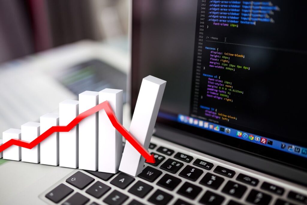 laptop con codice e grafico che simula crollo