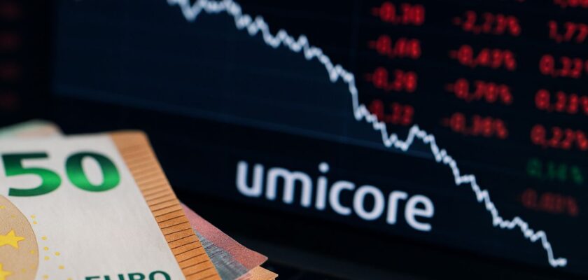 Alcune banconote in euro con la scritta Umicore sullo sfondo insieme a un grafico finanziario