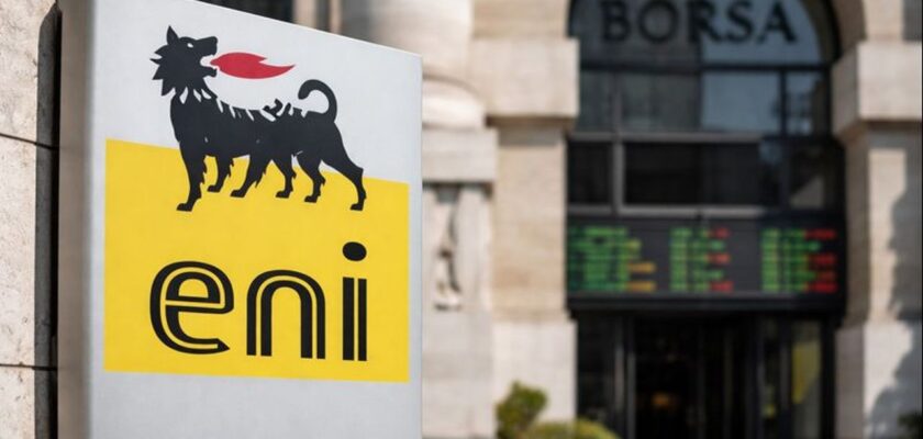 Logo Eni in primo piano su un totem pubblicitario con l'ingresso dell'edificio della Borsa sullo sfondo