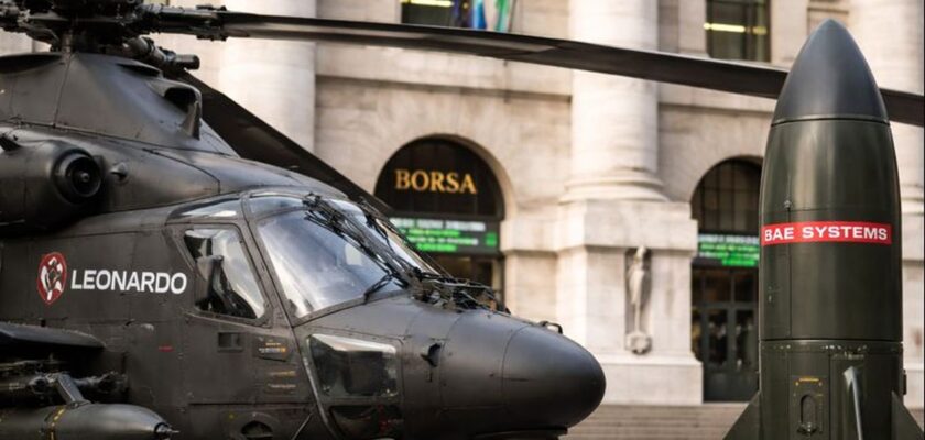 Un elicottero da guerra con il logo Leonardo e l'edificio della Borsa di Milano sullo sfondo