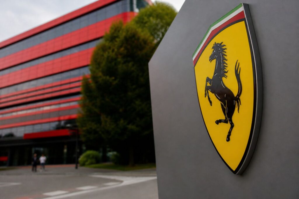 Logo Ferrari in primo piano davanti a edificio moderno