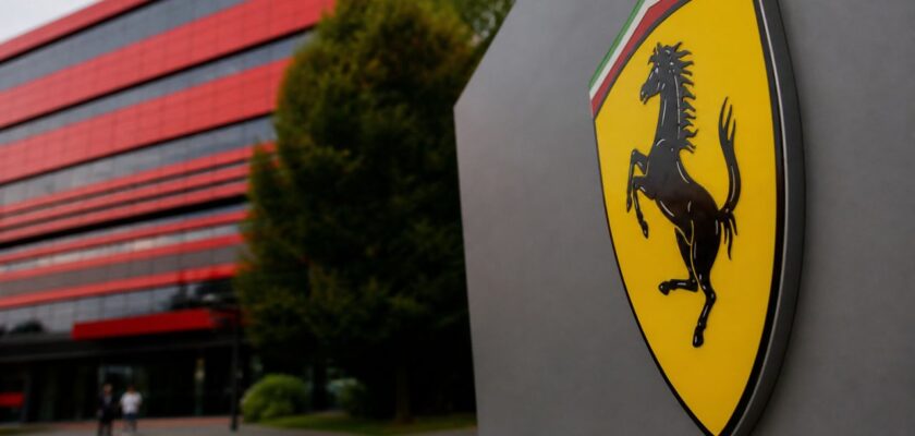 Logo Ferrari in primo piano davanti a edificio moderno