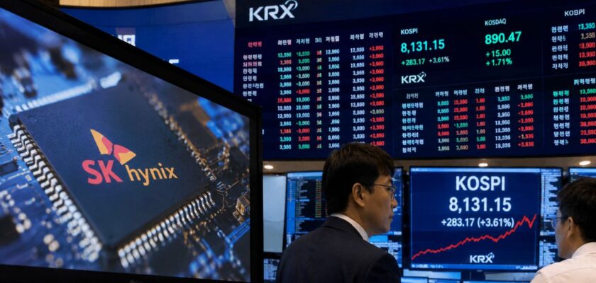 Trader davanti a schermi di Borsa con dati finanziari e grafici, accanto a un grande chip SK Hynix che richiama il settore dei semiconduttori e dell’intelligenza artificiale