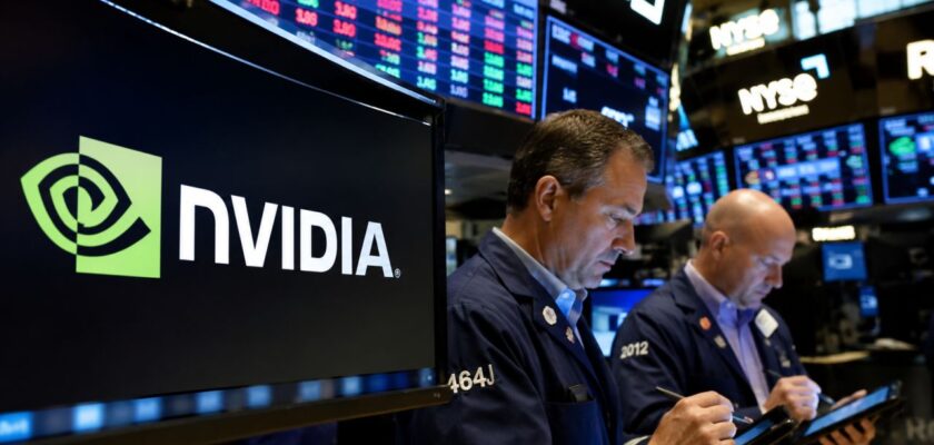 Operatori finanziari al lavoro sul floor di una borsa valori, con monitor che mostrano il logo Nvidia e dati di mercato in tempo reale sullo sfondo