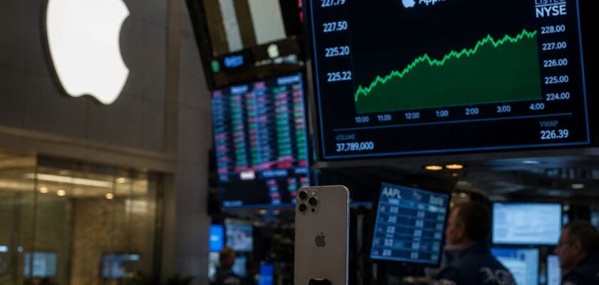 Monitor di Borsa in una sala di trading con il logo Apple ben visibile sullo sfondo