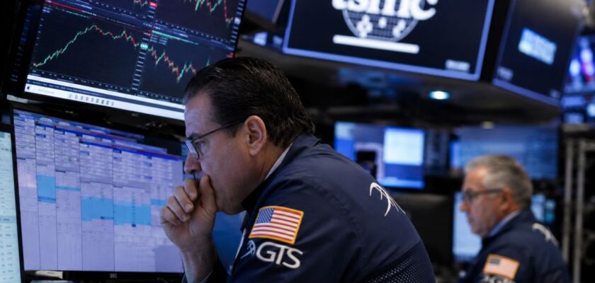 Trader davanti a monitor con grafici di Borsa e logo TSMC, in una sala operativa finanziaria