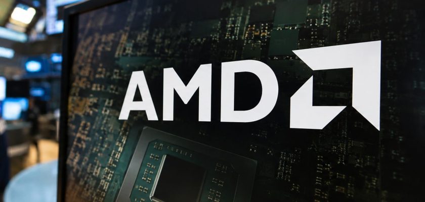Trader in una sala di Borsa davanti a monitor finanziari, con logo AMD e microchip in primo piano